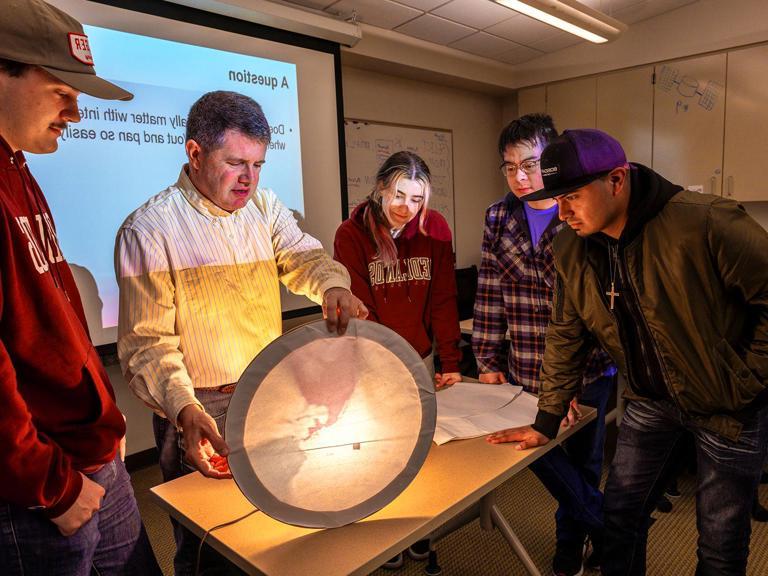 GIS Professor teaching students about light and maps.